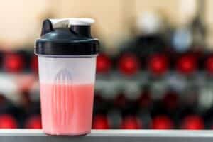 Plastic shaker with fitness cocktail in gym
