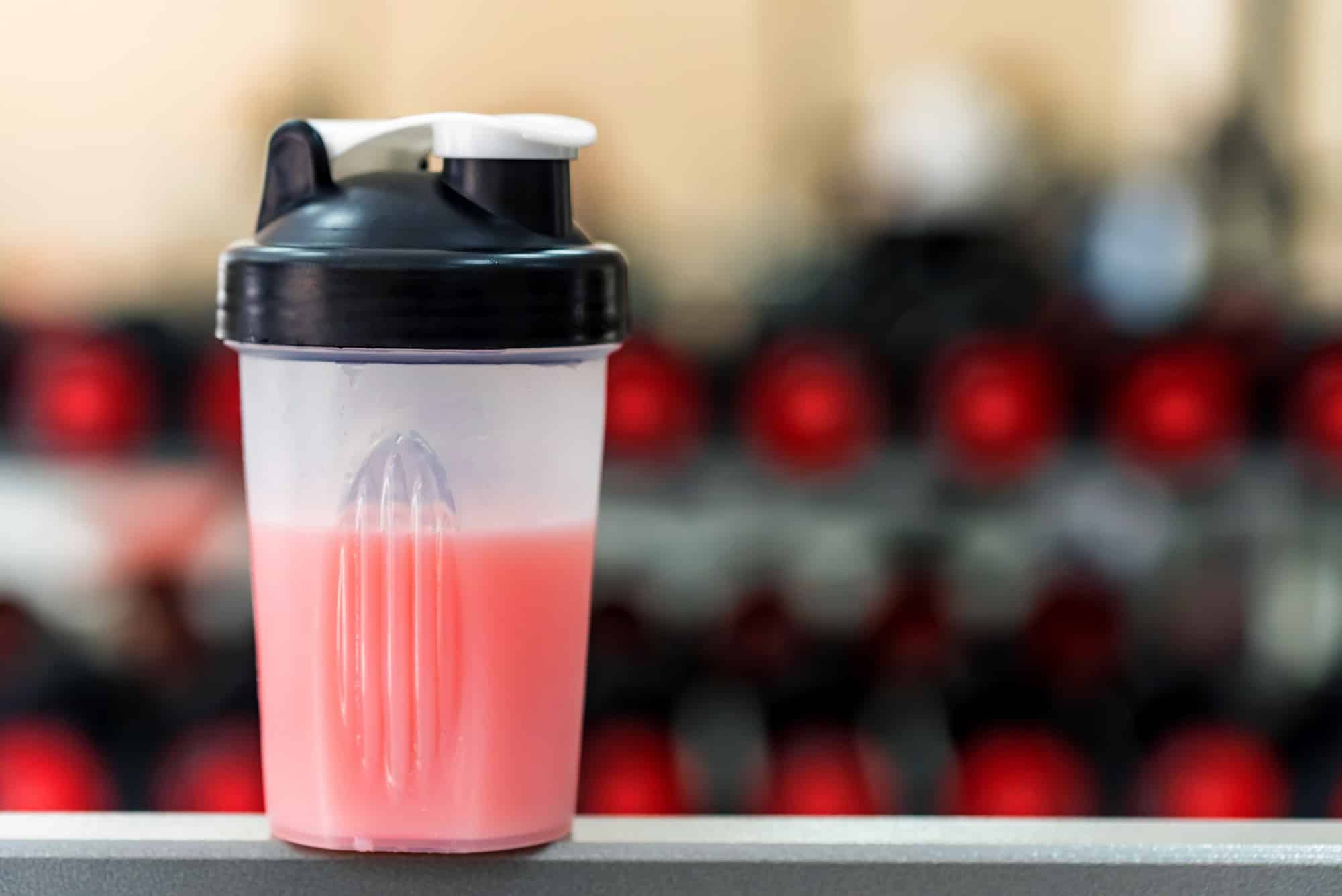 Plastic shaker with fitness cocktail in gym